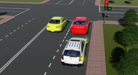 Beyaz araç sağa dönmek üzere sinyal verdiği halde kırmızı ışıkta bekliyor. Işıkta sadece sağa dönüşe izin veren yeşil ok — soru görseli